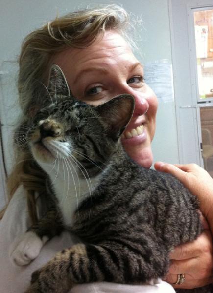 Katherine holding cat named Pixie, smiling at camera